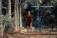 a woman in a brown dress posing in a forest